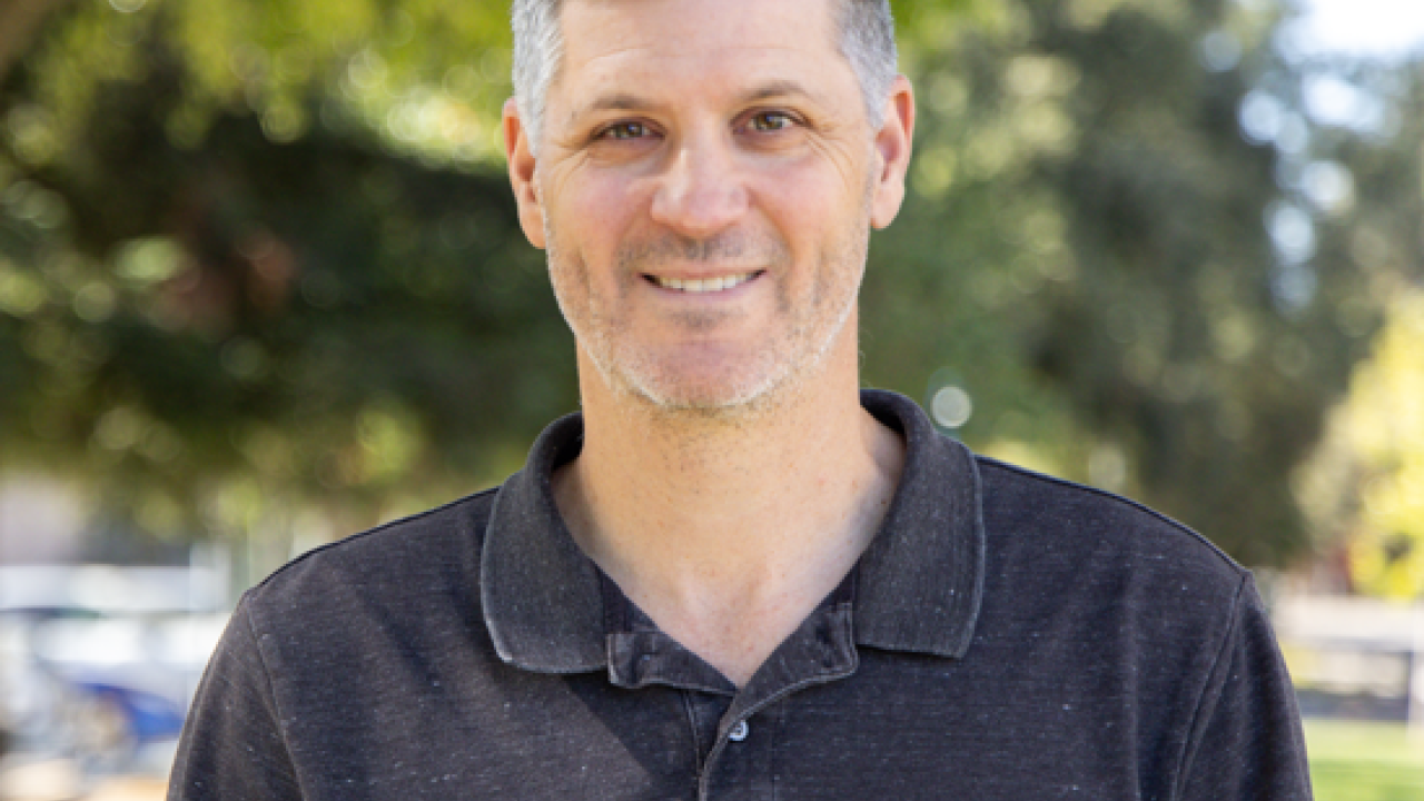Photo of Sam King. He is a white male wearing a black polo shirt.